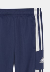 Marineblauwe sportbroeken met witte accenten, elastische tailleband, gestructureerde stof en een Adidas-logo op de zijzak.