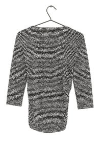 Svart och vit topp med prickmönster, rund halsringning, trekvartslånga ärmar och en mjuk tygkänsla. Hänger på en krok.