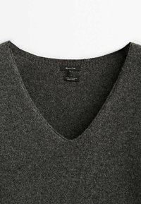 Grå uld-kashmir trøje med dyb V-udskæring, blød og glat tekstur samt ribbet kant. Vaskeanvisning synlig indvendigt.