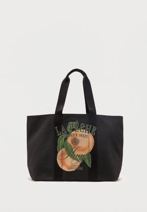Zwarte draagtas met twee handvatten, met een perzikafbeelding en de tekst "La Pêche Juicy & Sweet Hugo Saint-Tropez" aan de voorkant.