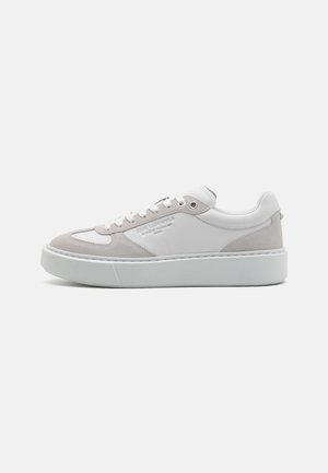 Baltas un gaiši pelēks ādas un zamšādas sneaker, ar noapaļotu purngalu, plakanu sajūga dizainu un biezu baltu gumijas zoli.