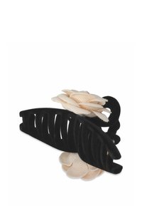 Svart sammetsfrisyrklipp med ett snidat mönster och en beige tygblomma som accent. Böjd form, texturerad yta och öppna spalter för grepp.