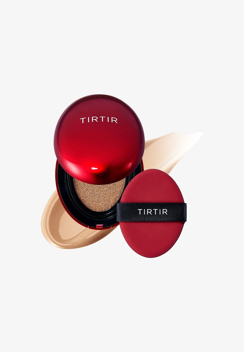 Compatto rosso con finitura lucida, contenente un applicatore a spugna e un fondotinta cushion. Campione di fondotinta cremoso accanto al compatto.