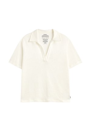 Kremowa koszulka polo z krótkim rękawem, otwartym kołnierzykiem, miękkim materiałem i ekologiczną metką nadrukowaną wewnątrz karku.