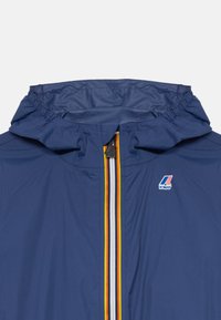 Veste à capuche bleue avec fermeture éclair à l'avant, ornée de rayures rouges, jaunes et blanches, ainsi qu'un petit logo K-Way sur la poitrine.