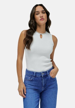 Ribbed white sleeveless top with a keyhole neckline detail and a sparkly trim, paired with high-waisted blue denim jeans.