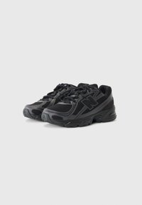 Schwarze Sportschuhe mit einem Obermaterial aus Mesh und Synthetik, Schnürdesign, abgerundetem Zehenbereich, gepolsterter Sohle und seitlichem Logodesign.