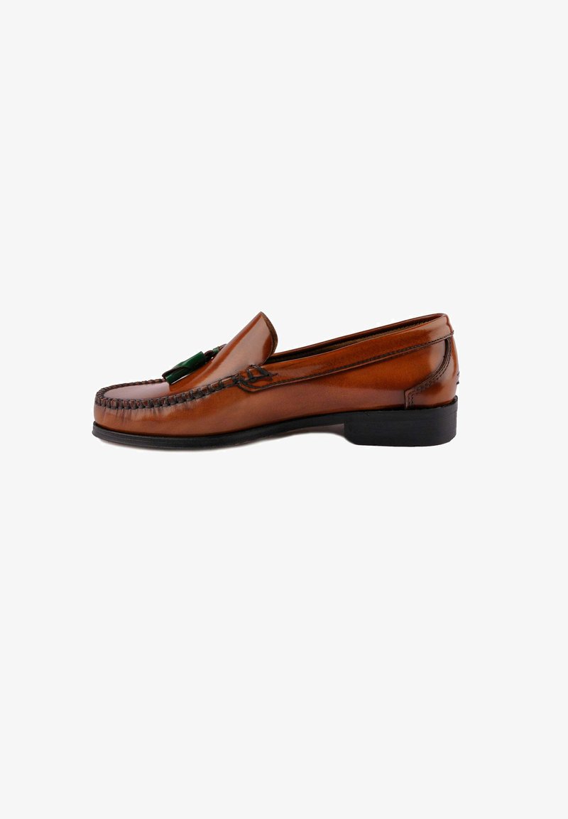 Mocasines de cuero marrón con costura trenzada y un acento decorativo verde, con punta redondeada y un bajo tacón negro de goma.