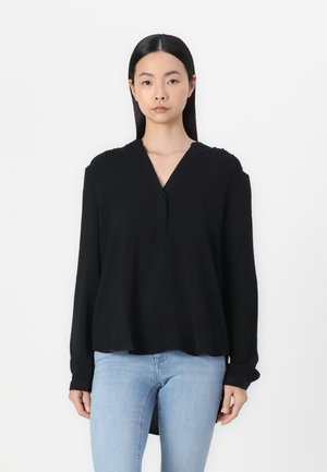 Black long-sleeve top with a V-neck and button detail, made of soft fabric. The design features a relaxed fit and a slightly longer back hem.