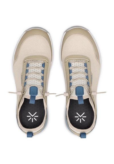 Beige athletic shoes with a textured mesh upper, blue accents, elastic laces, and a dark insole featuring a white logo.