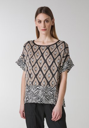 Korte mouw top met een zwarte basis en een geometrisch patroon in beige en crème, benadrukt met een zebraprint zoom. Glad textuur van de stof.