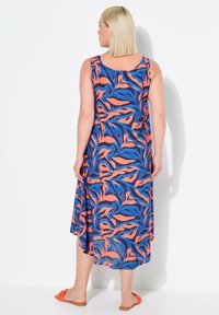Vestido de patrón floral con un diseño sin mangas en naranja, azul y marino, hecho de tejido ligero, con un dobladillo asimétrico.