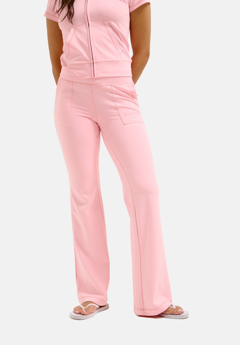 Lichtroze trainingspak met een top met korte rits en uitlopende broekspijpen, met voorzakken en een gladde, elastische stoftextuur.