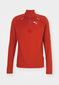 Rotes langärmliges Sportshirt mit einem Viertelreißverschluss, das weiße Akzente und ein Logo auf der oberen linken Seite aufweist. Hergestellt aus einem glatten, dehnbaren Material.