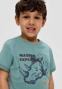 Katoenen T-shirt met korte mouwen in licht tealgroen, met een neushoornafbeelding en in het donkerblauw gedrukt de tekst "MASTER EXPLORER". Gestructureerd ontwerp.
