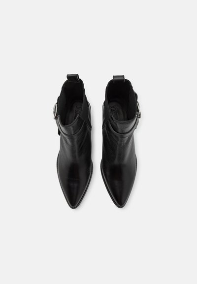 Bottines en cuir noir avec un embout pointu, fermeture éclair à l'arrière et détail de boucle sur le côté. Texture lisse avec un minimum de coutures.