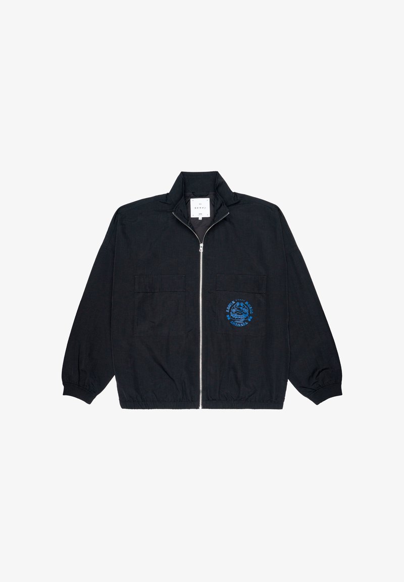 Veste noire zippée avec un col montant, dotée de deux poches avant et d'un graphique bleu sur la poitrine gauche. Le matériau semble léger et texturé.