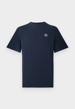 Marineblå bomulds t-shirt med korte ærmer og rund halsudskæring. Har et lille hvidt logo på venstre bryst. Glat tekstur.