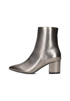 Metallisch silberner Knöchelstiefel mit spitzem Schuhbereich und Blockabsatz, der ein elegantes und modernes Design zeigt. Vor einem weißen Hintergrund präsentiert.
