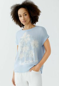 Helles blaues T-Shirt mit kurzen Ärmeln und lässiger Passform, mit einem weißen Palmen-Graphic und Textdesign, aus glattem, leichtem Stoff gefertigt.