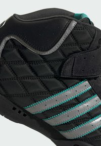 Čierne vysoké tenisky s prešívaným textilným dizajnom, sivými syntetickými akcentmi a detailmi v tyrkysových pruhoch. Zatváranie na suchý zips.