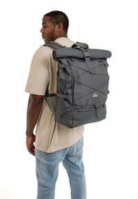 Black roll-top backpack with a textured surface, adjustable straps, side pockets, and an exterior bungee cord for securing items.