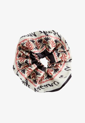 Stoff-Scrunchie mit rotem und schwarzem Blumenmuster auf cremefarbenem Hintergrund und schwarzem kursivem Text an den Rändern.