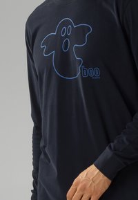 Granatowa koszulka z długim rękawem z grafiką niebieskiego ducha z napisem "boo" i "ATLANTIC" poniżej. Wykonana z miękkiego materiału bawełnianego.