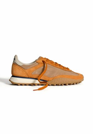 Baskets orange et beige en cuir et en mesh, avec un bout arrondi, des accents texturés et une semelle en caoutchouc blanc avec des crampons de traction.