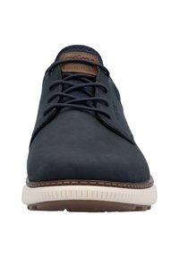 Chaussures en cuir bleu foncé avec une finition lisse, à lacets plats et une semelle de couleur claire contrastante. Accents marron sur la langue.