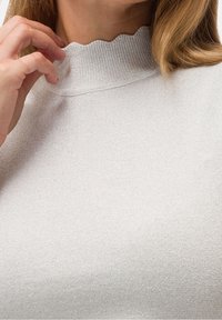 Pull en tricot côtelé gris clair avec un col festonné et un léger éclat. Design ajusté, avec une texture lisse.