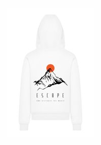White hoodie featuring a black mountain graphic and an orange sun. Text reads "ESCAPE AND DISCOVER THE WORLD" below the design.