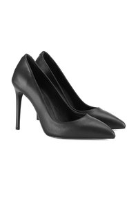 Une paire d'escarpins noirs à bout pointu avec des talons aiguilles fins, présentée sur un fond blanc.