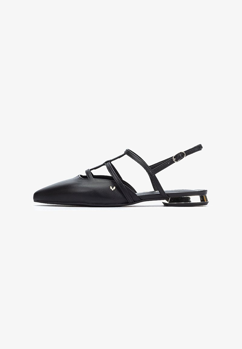 Ballerines noir en cuir à dos nu avec un bout pointu, des sangles croisées et un petit accent métallique sur le talon. Texture lisse tout au long.