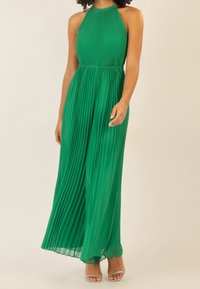 Vestido maxi plisado verde con diseño de cuello halter; tela fluida con una textura suave; presenta una cintura ajustada y una silueta larga y caída.