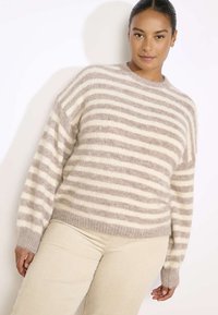 Maglione a righe in beige chiaro e crema, realizzato in un materiale morbido e peloso. Presenta spalle scese e polsini a coste con una vestibilità rilassata.
