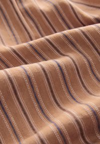 Tessuto a righe marrone, con sottili linee blu e bianche. La trama appare liscia con una leggera lucentezza nelle pieghe drappeggiate.