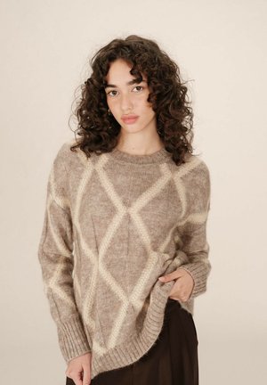 Pull en tricot beige avec un motif en losanges blanc cassé. Doté d'un col et de poignets côtelés, d'une texture douce et d'une coupe légèrement oversize.
