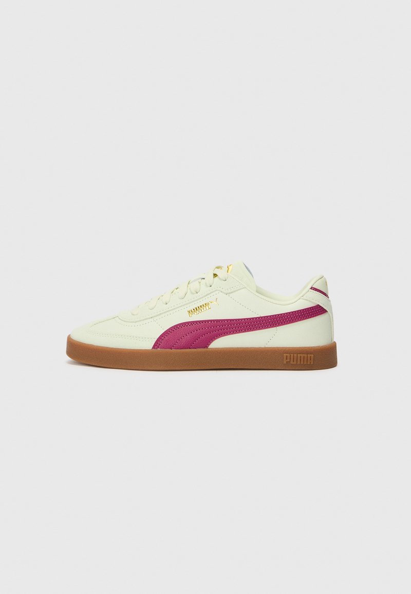Adidași galbeni deschiși, cu o dunga fucsia Puma, talpă din gumă și accente texturate subtile. Șireturile și brandingul sunt de culoare aurie.