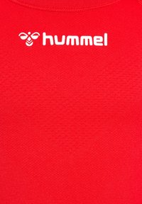 Rotes Sportshirt aus glattem Material, mit einem weißen "hummel"-Logo und einem Rundhalsausschnitt.