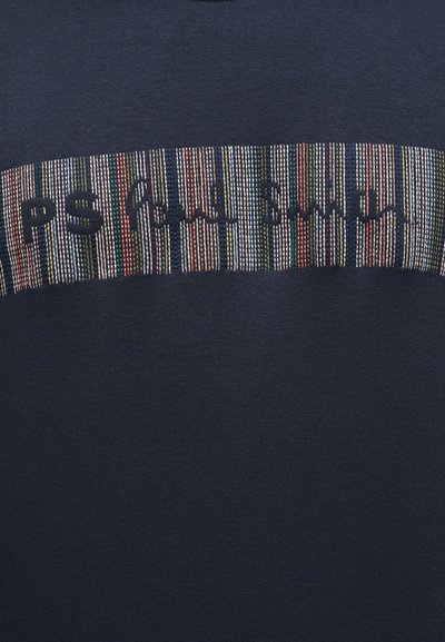 Ναυτικό ύφασμα με οριζόντια πολύχρωμη λωρίδα και μαύρο κεντητό κείμενο που γράφει "PS Paul Smith."