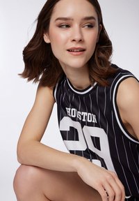 Canotta da basket nera senza maniche con righe bianche, caratterizzata dal testo "HOUSTON" e dal numero "29" in grande carattere bianco.