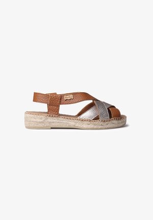 Rudos odinės šlepetės su metalizuota sidabro spalvos kryžmine juostele; jutas apvyniota padas; atvira noselė; plokščias kulnas komfortui.