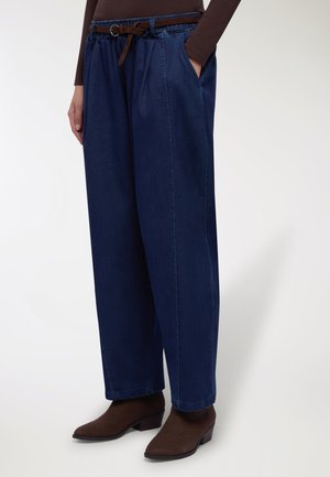 Pantaloni in denim blu scuro con vestibilità comoda, dotati di vita con coulisse, tasche laterali e dettagli marroni sulla cintura.
