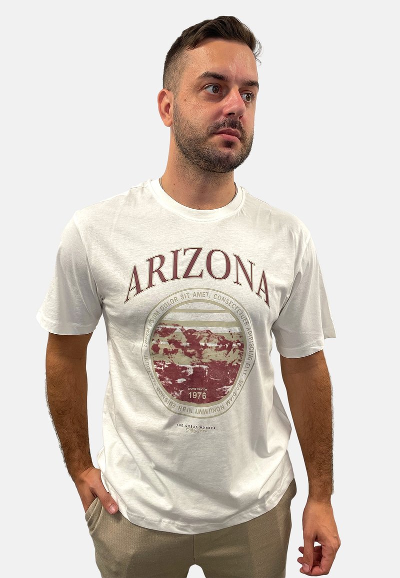 Weißes Baumwoll-T-Shirt mit einem runden Grand Canyon-Design in Rot und Schwarz, mit dem Text "ARIZONA" darüber und "1976" darunter.
