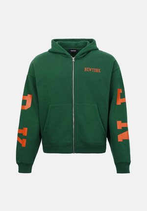 Zelená mikina na zips s prednými vreckami, oranžovým nápisom "NEWYORK" na hrudi a oranžovými nápismi na oboch rukávoch.