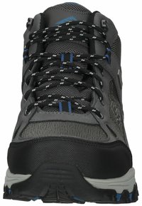 Zapato de senderismo gris con materiales de malla y sintéticos, que presenta acentos negros, detalles azules y una suela texturizada para tracción. Los cordones son oscuros.