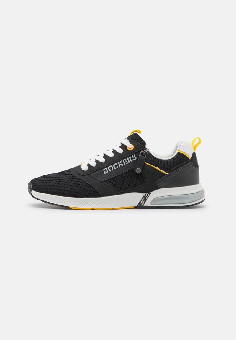 Schwarz-weißer Sportschuh mit gelben Akzenten, Mesh-Obermaterial, weißen Schnürsenkeln, Reißverschluss-Detail und gepolsterter Sohle mit dem Markennamen „Dockers“ an der Seite.