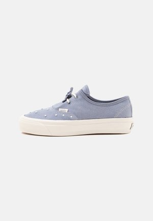 Hellblaue Vans Low-Top-Sneaker mit weißer Gummisohle, weißen Ösen, schwarzen Schnürsenkeln und kleinen weißen Punktverzierungen am Obermaterial.