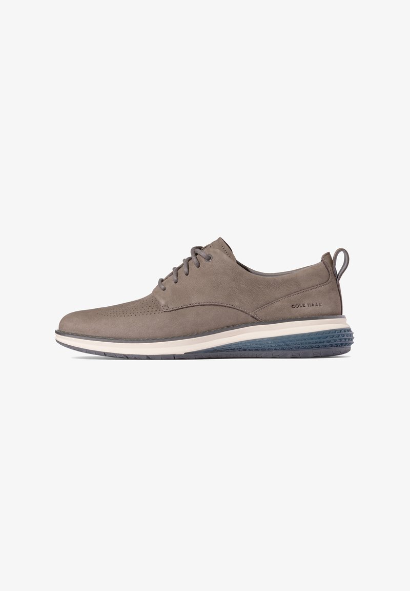 Grå ruskinds sneaker med perforerede detaljer, snørrede design og hvid mellemsål. Textureret mørkeblå gummisål og hængetab ved hælen.